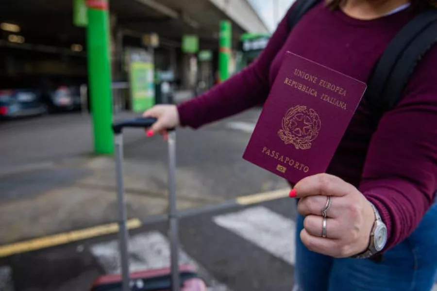 Mulher segurando o passaporte mais poderoso do mundo: o passaporte italiano.